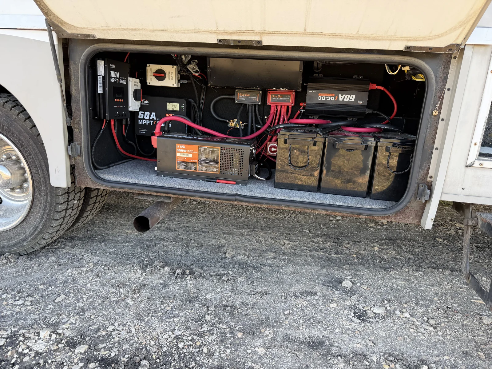 Motorhome bay with a lithium battery bank, an inverter charger and solar charge controllers wired in, RV electrical repair
