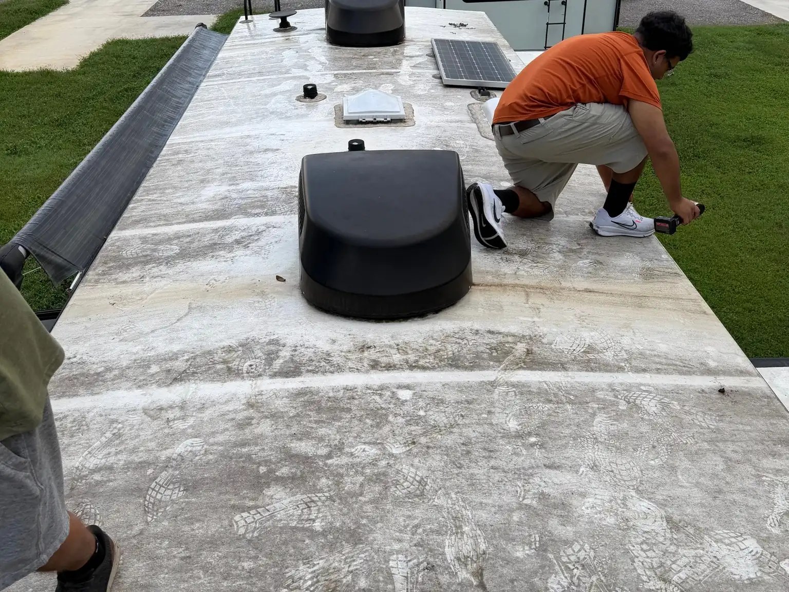 Technician checking an RV roof at an RV park, RV maintenance