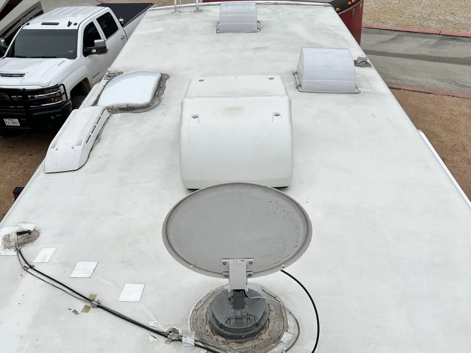 RV roof with resealed vents and a satellite dish after service, RV maintenance