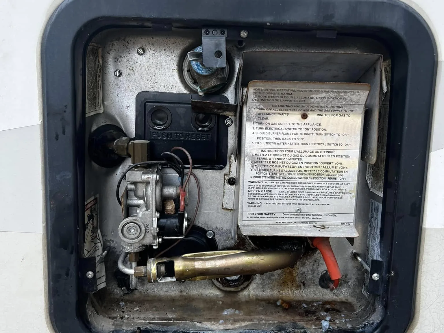 RV water heater compartment open for service, RV plumbing and water heater repair
