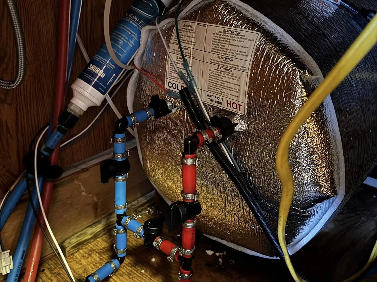 Water lines and fittings behind an RV water heater, RV plumbing and water heater repair