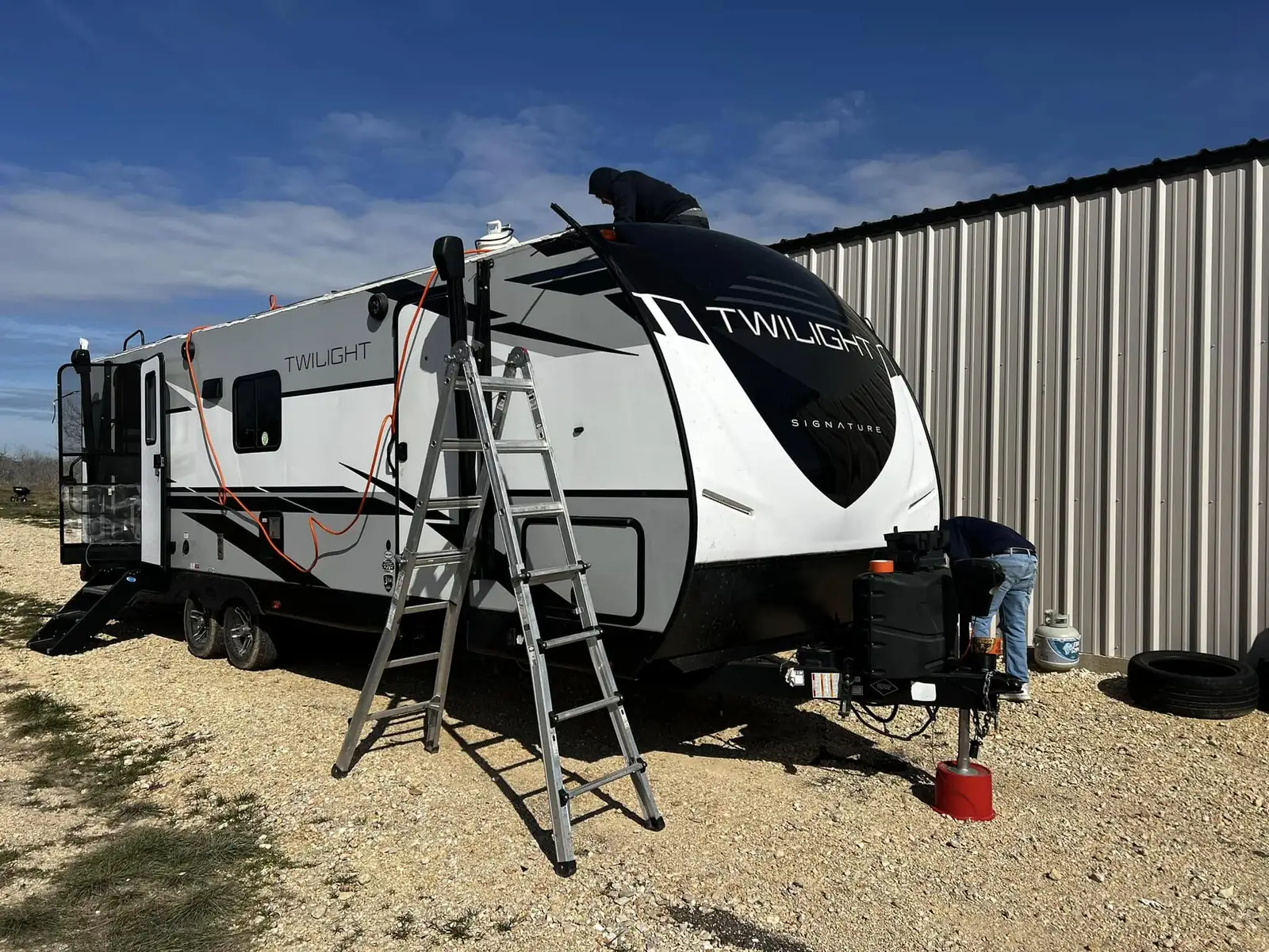 Travel trailer with a ladder set up during a roof replacement, RV roof repair