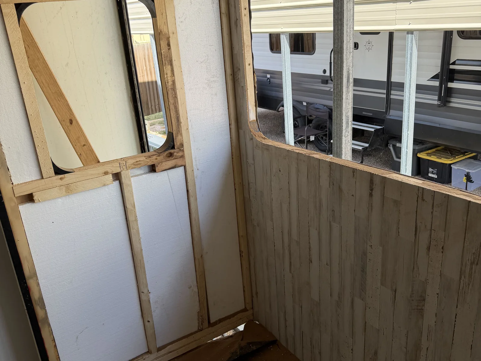 New window framing and a fresh wall panel inside a travel trailer during a wall rebuild, RV body repair