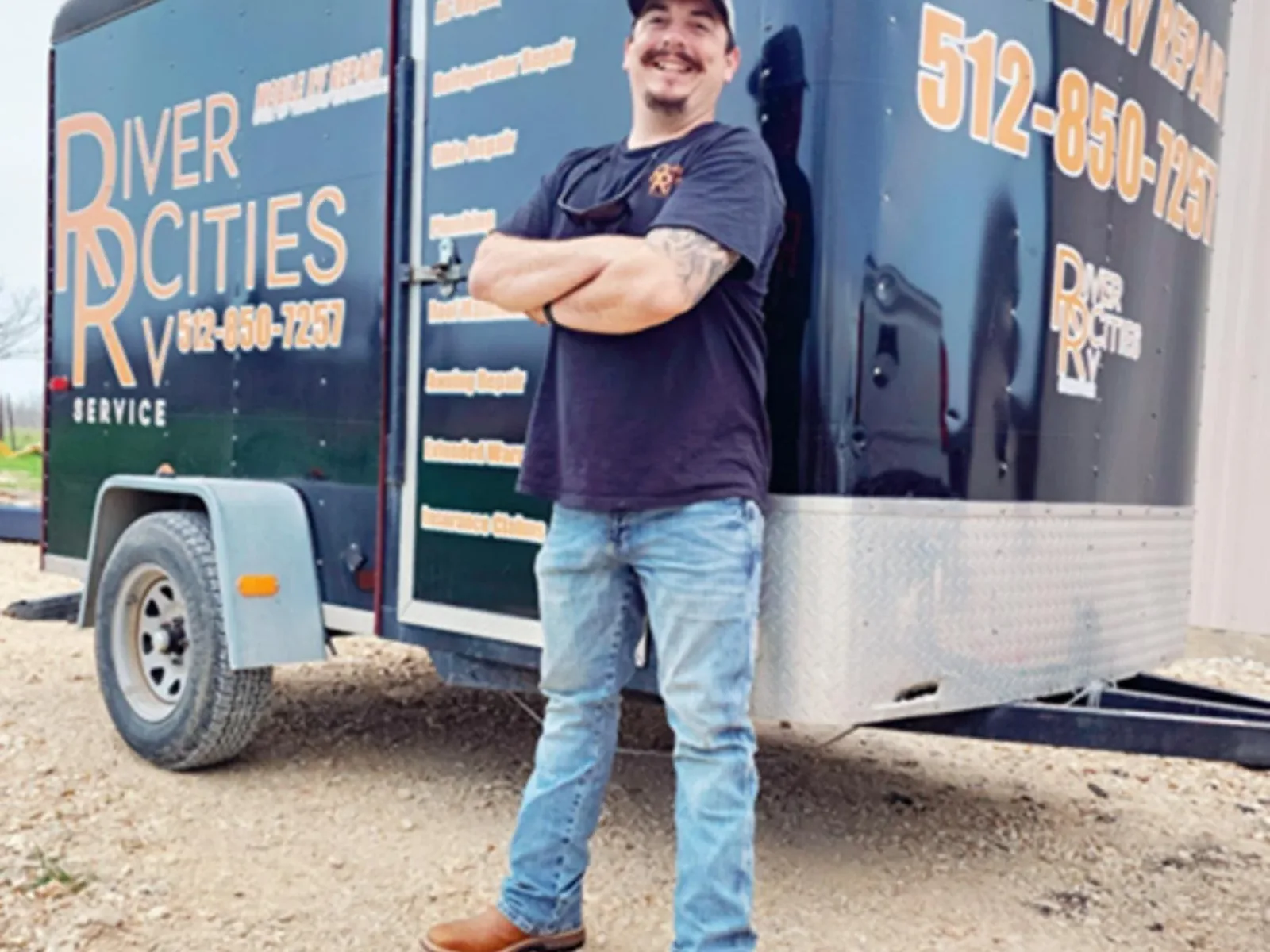 Technician standing in front of the River Cities RV Service mobile repair trailer, mobile RV repair